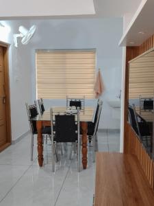 a dining room with a wooden table and chairs at V Land Homestay in Vagamon