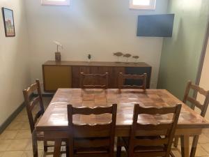a wooden dining room table with chairs and a television at Val et Mer House in Ault
