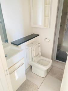 een witte badkamer met toilet en douche bij Kingelph Stylish 1- Bedroom Apartment in Windhoek