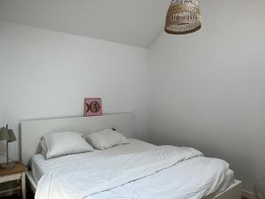 a white bed with two pillows on top of it at Ons Bijhuis in Wijk aan Zee