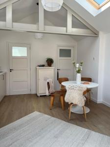 a white living room with a table and chairs at Ons Bijhuis in Wijk aan Zee +10 photos