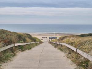 a sidewalk leading to a beach with the ocean at Ons Bijhuis in Wijk aan Zee