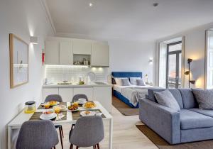 a living room with a couch and a table with food on it at Porto Apartments - Bombarda 451 Suites in Porto