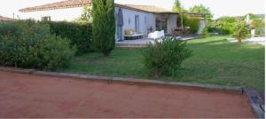 een achtertuin met een huis en een tuin met een terras bij Villa Entonofa in Nans-les-Pins +3 foto's