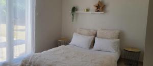 een slaapkamer met een bed met witte lakens en kussens bij Villa Entonofa in Nans-les-Pins