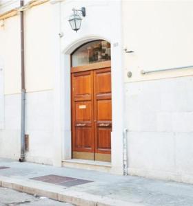 een houten deur aan de zijkant van een gebouw bij Tiare' in Trani