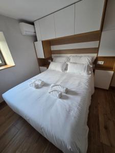 un grande letto bianco con due asciugamani sopra di Quinta da Estacao a Marco de Canaveses