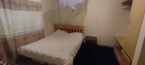 una piccola camera da letto con un letto e una finestra di Airbnb in Mwea town Kabulstan apartment a Thiba