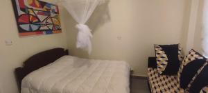 una camera da letto con un letto e un quadro sul muro di Airbnb in Mwea town Kabulstan apartment a Thiba