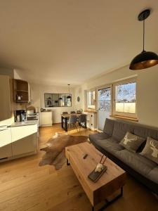 un soggiorno con un divano e un tavolo di Haus Steinplatte a Waidring