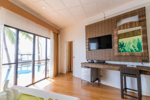 a living room with a tv on a wall at Mamburise Resort in Batan