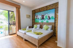 a bedroom with two beds and a painting on the wall at Mamburise Resort in Batan