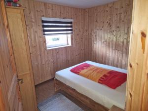 a small bedroom with a bed and a window at Halmis FeWo in Derenburg