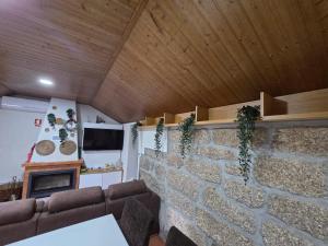 un soggiorno con un muro in pietra e un camino di Quinta da Estacao a Marco de Canaveses