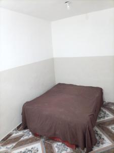 ein kleines Zimmer mit einem Bett mit einer braunen Decke in der Unterkunft Cabeza De Toro, Locales in Punta Cana