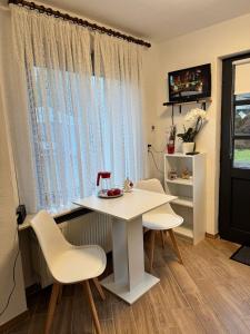 een witte tafel en stoelen in een kamer met een raam bij Studio Ohlendorf 3 Min zur A7 in Seevetal +14 foto's