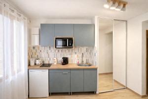 a kitchen with a sink and a microwave at Studio - Lit double - Proche Centrex & Disneyland in Noisy-le-Grand
