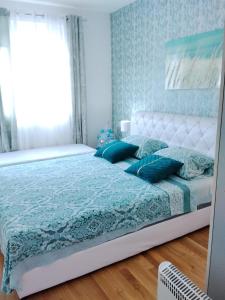 een slaapkamer met een wit bed met blauwe kussens bij GREEN HILL Lux Apartments in Soko Banja