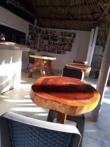 un tavolo e delle sedie con una tavola di legno sopra di Hostal Paloma Café a Palomino