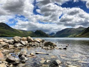 a group of ducks swimming in a lake with mountains at Scale Hill Hotel in Loweswater