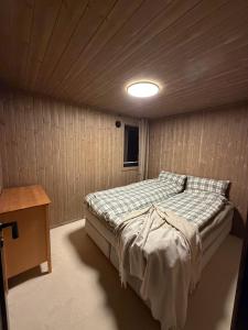 a bedroom with a bed in a wooden room at Exclusive Cabin with Sauna in Fossmo