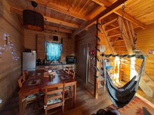 een eetkamer met een hangmat in een blokhut bij Gawra Nad Jeziorem - całoroczne domki nad jeziorem z balią, jacuzzi i sauną, Kaszuby in Sobącz +57 foto's