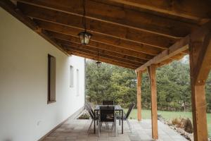a patio with a table and chairs under a wooden ceiling at Prázdninový dům Sobotín in Sobotín