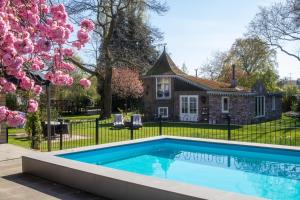 a swimming pool in front of a house at Pipowagen de Luxe, prive hottub en zwembad in Heythuysen