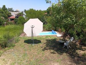 een witte parasol naast een zwembad bij casa fin de semana in Paraná