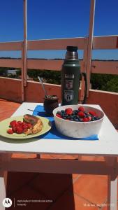 einen Tisch mit einer Schale Obst und einem Teller Essen in der Unterkunft Miramar 7C un ambiente in Miramar