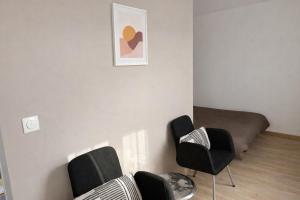 a room with a bed and chairs in it at Studio - Lit double - Proche Centrex & Disneyland in Noisy-le-Grand