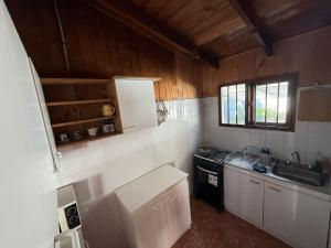 a small kitchen with a stove and a sink at Casa en el centro de Licanray in Licán Ray