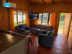 a living room with couches and chairs and a television at Casa en el centro de Licanray in Licán Ray