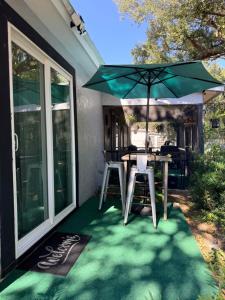 een patio met een tafel en een parasol bij Dos alcobas, entrada independiente in Kissimmee