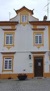 a white building with a black door and windows at Casa Atelier Designer Moda Sandra Silva in Alpalhão