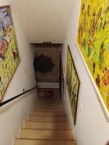 a hallway with paintings on the walls and stairs at Casa Atelier Designer Moda Sandra Silva in Alpalhão