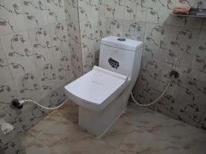 a bathroom with a white toilet in a room at Sangam Sathi in Prayagraj