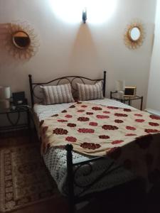 a bedroom with a bed with a floral comforter at Casa Atelier Designer Moda Sandra Silva in Alpalhão