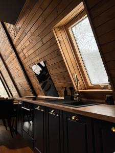 an attic kitchen with a sink and a window at Lakewood Cabin - Surduc Lake in Fîrdea +25 photos