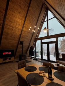 a room with a table and chairs and a large window at Lakewood Cabin - Surduc Lake in Fîrdea
