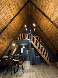 a staircase in a room with a table and chairs at Lakewood Cabin - Surduc Lake in Fîrdea