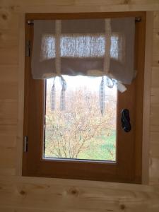 een raam in een kamer met een gordijn bij Roulotte & Respire in Foussemagne
