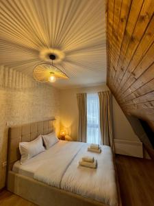a bedroom with a large bed with towels on it at Lakewood Cabin - Surduc Lake in Fîrdea