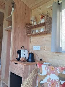 een kamer met een houten muur met een tafel en een lamp bij Roulotte & Respire in Foussemagne