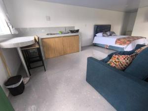 a room with a bed and a couch and a table at Cabaña El Laurel in Pasto