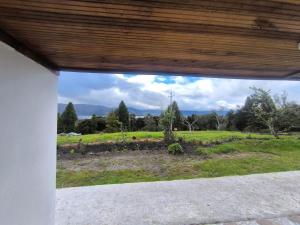 a view of a field from a porch at Cabaña El Laurel in Pasto