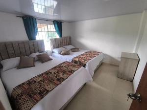 a bedroom with two beds and a window at Cabaña El Laurel in Pasto