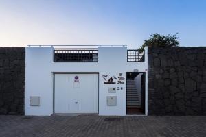 a white building with a door and a wall at Villa Pola Marinas Playa B in Playa Blanca
