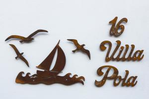 a group of wooden objects with a sailboat and the wordilla pizza at Villa Pola Marinas Playa B in Playa Blanca