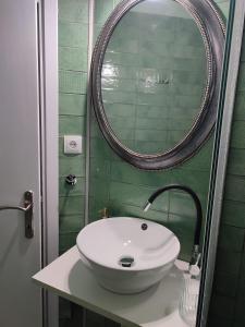 un bagno con un lavandino bianco e uno specchio di La Familia a Veria Altre 5 foto